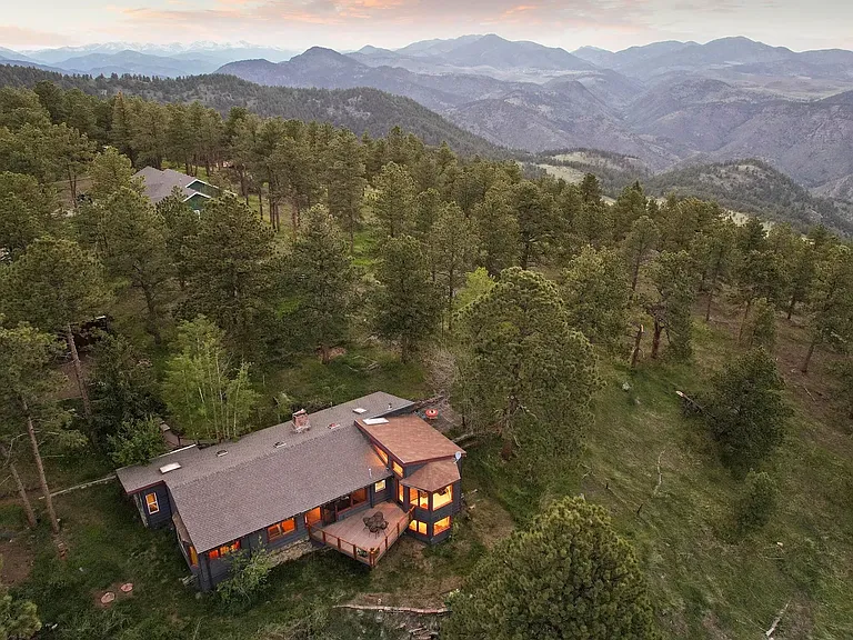 Aerial view of house set within protected national forest land
