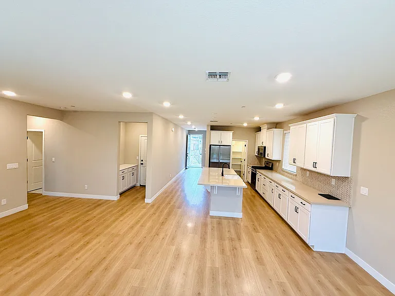 Open floor plan (Living area, garage exit, and Kitchen)