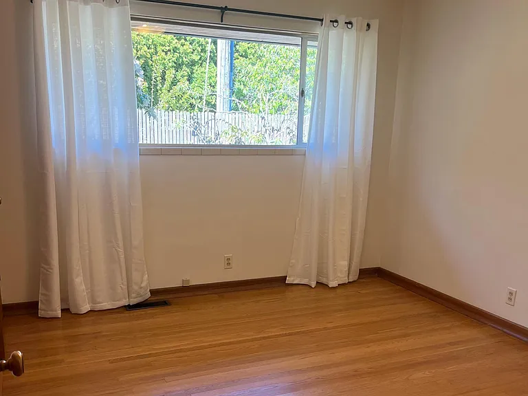 Bedroom 3 with hardwood floors and new curtains.