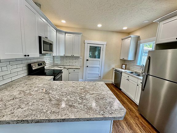 Kitchen with eating bar. The door in this photo opens to the back covered area and detached storage building.