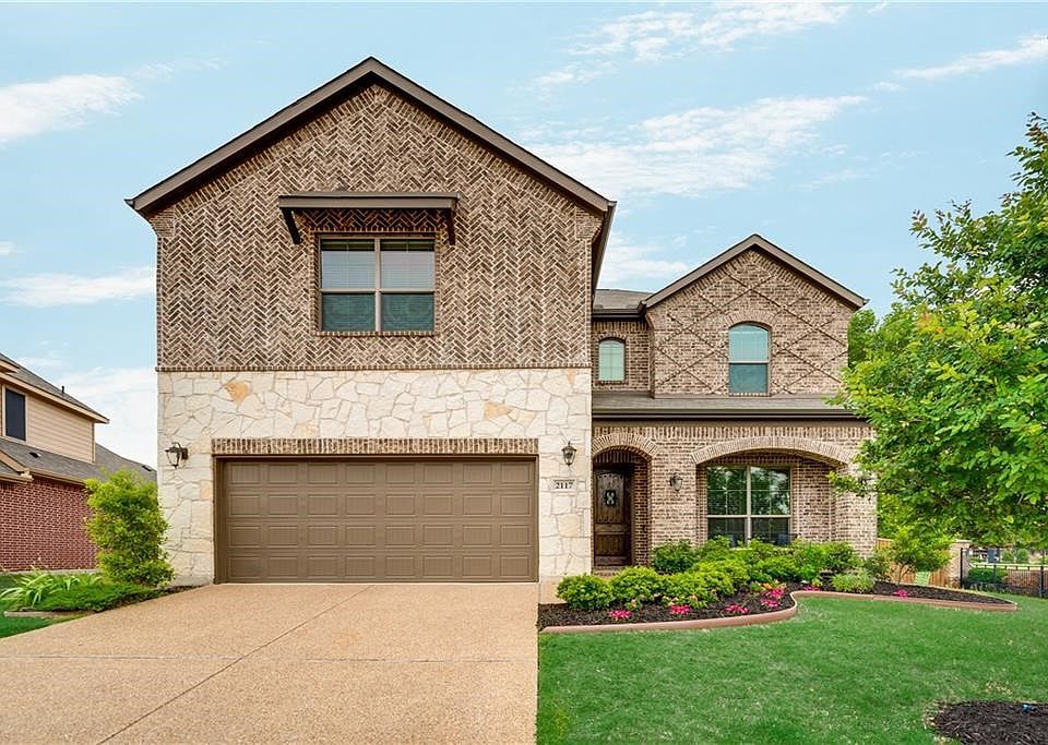 Gorgeous Megatel home with brick and stone mixed elevation and beautiful landscaping with cozy front porch!