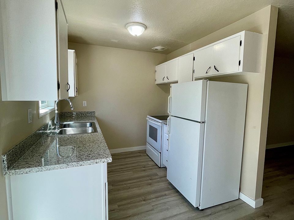 Kitchen with new hardwood floor, counters, and granite countertops.