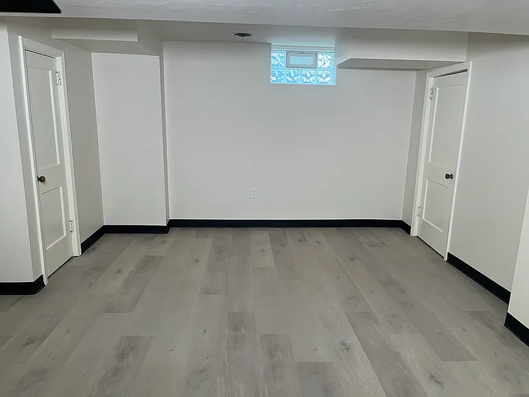 Side view of finished basement. Left door to bathroom and right door to large storage closet.