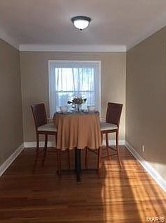 Dining room with newly refinished hardwood flooring with new baseboard trim and new large window overlooking the fenced backyard.