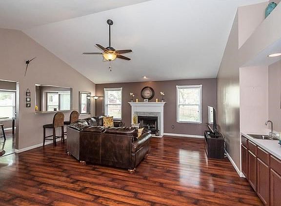 Spacious Great Room with Vaulted ceiling, gas fireplace, wet bar with extra storage, recessed lighting. The Kitchen and main floor laundry are to the left.