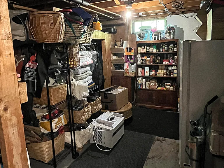 Large storage room (one of two) in basement, complete with a closet and an upright freezer for your use. Shelving shown in photos belong to previous tenants and will be removed prior to move-in.
