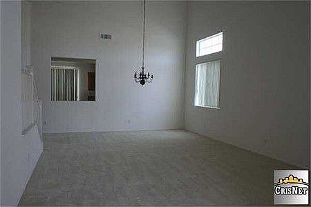 Entry from covered porch to formal living and dining with two story ceiling