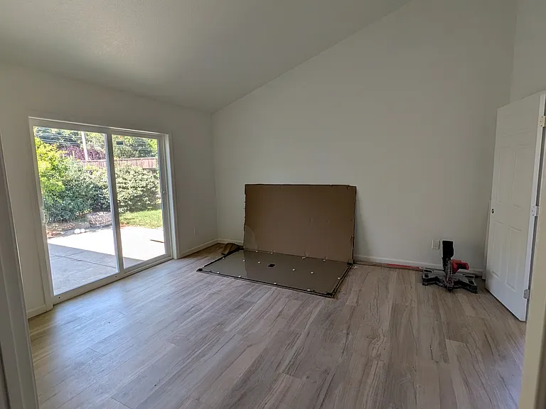 Primary Bedroom with vaulted ceiling and a sliding glass door to the back patio. (Bedroom 3)