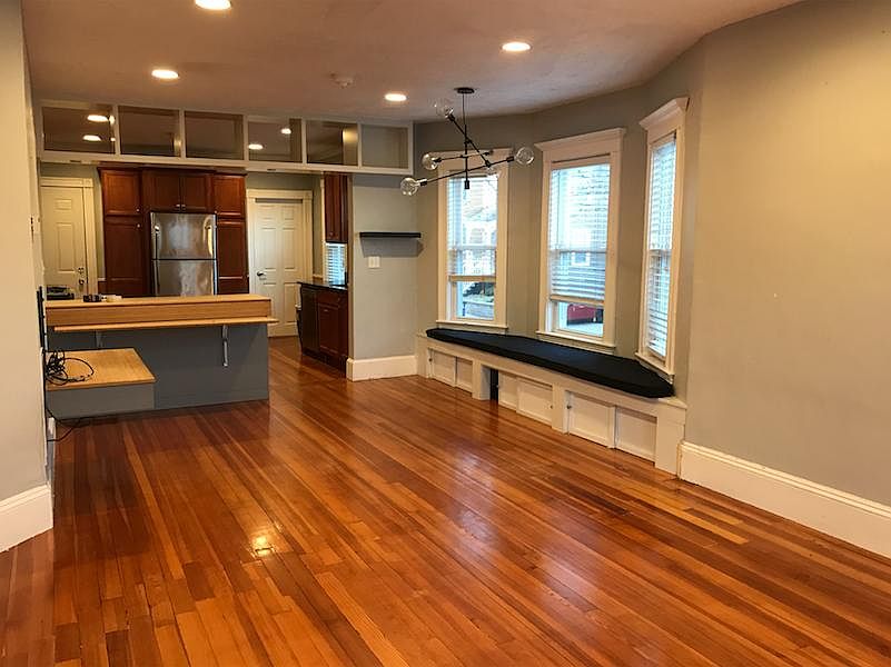View of dining area with built in seating (right) and kitchen.