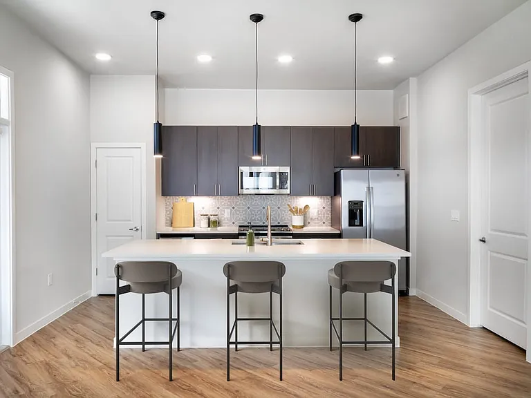 Kitchens with stainless steel appliances, wine fridges, quartz countertops, tile backsplash, and hard surface flooring