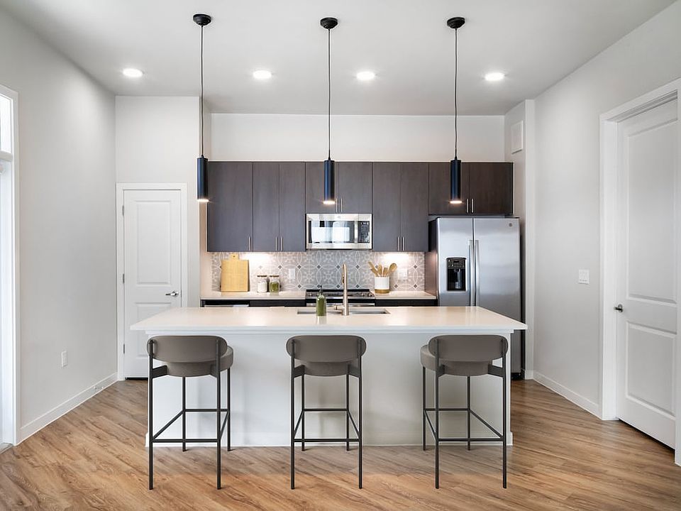 Kitchens with stainless steel appliances, wine fridges, quartz countertops, tile backsplash, and hard surface flooring