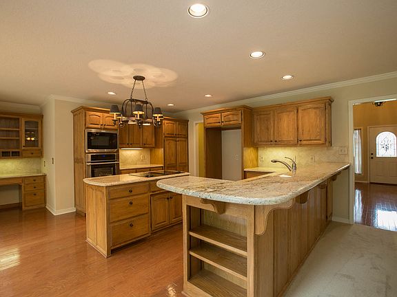 Open Kitchen with new granite counters, new tumbled marble backsplash, breakfast bar, spacious center island and stainless steel appliances.