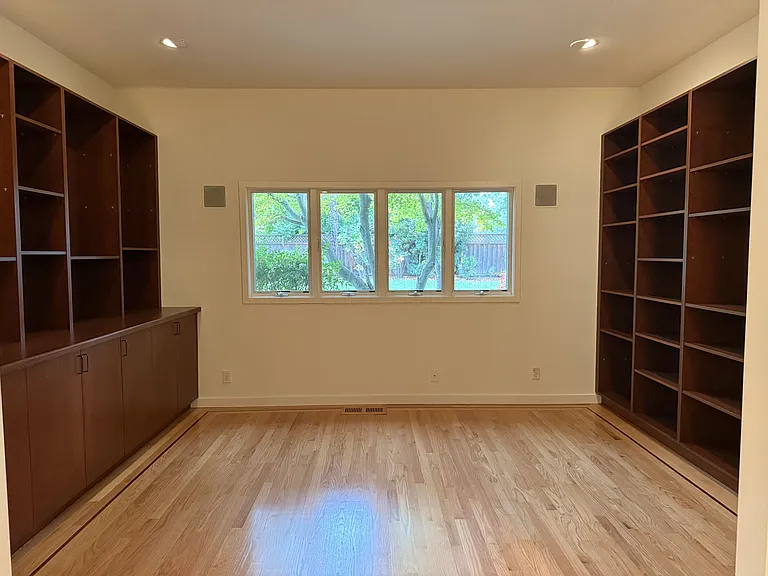 Private office features a built-in wall desk and library cabinetry.