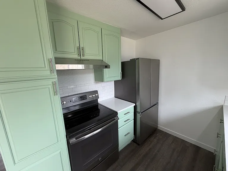 Other side of the galley kitchen. Range and refrigerator/freezer.