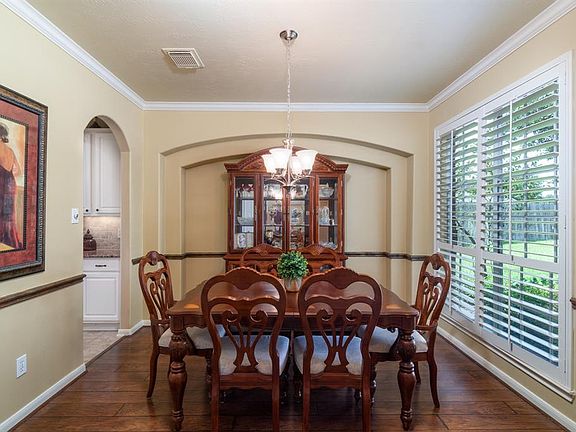 Just off the entry, is this gorgeous formal dining room! Architectural details include an arched inset, crown molding, chair rail and Plantation shutters!