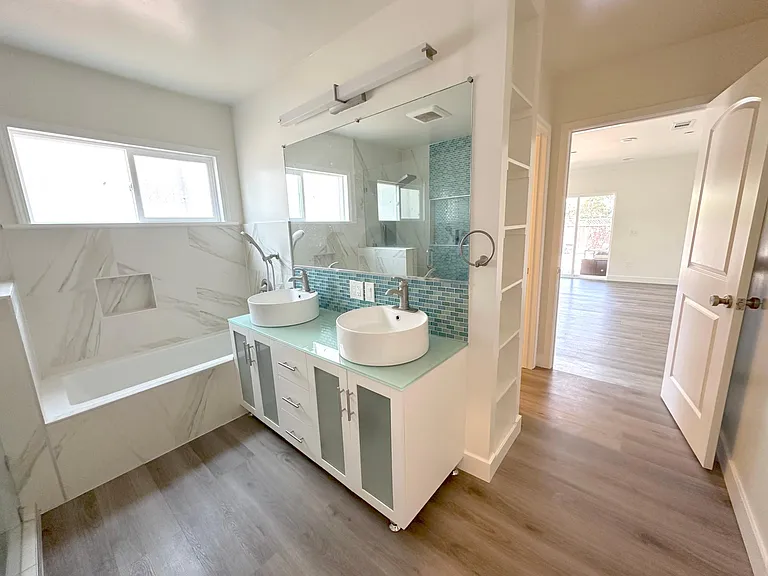 master bathroom with walk-in closet complete with shower, tub, toilet, and his/her sinks