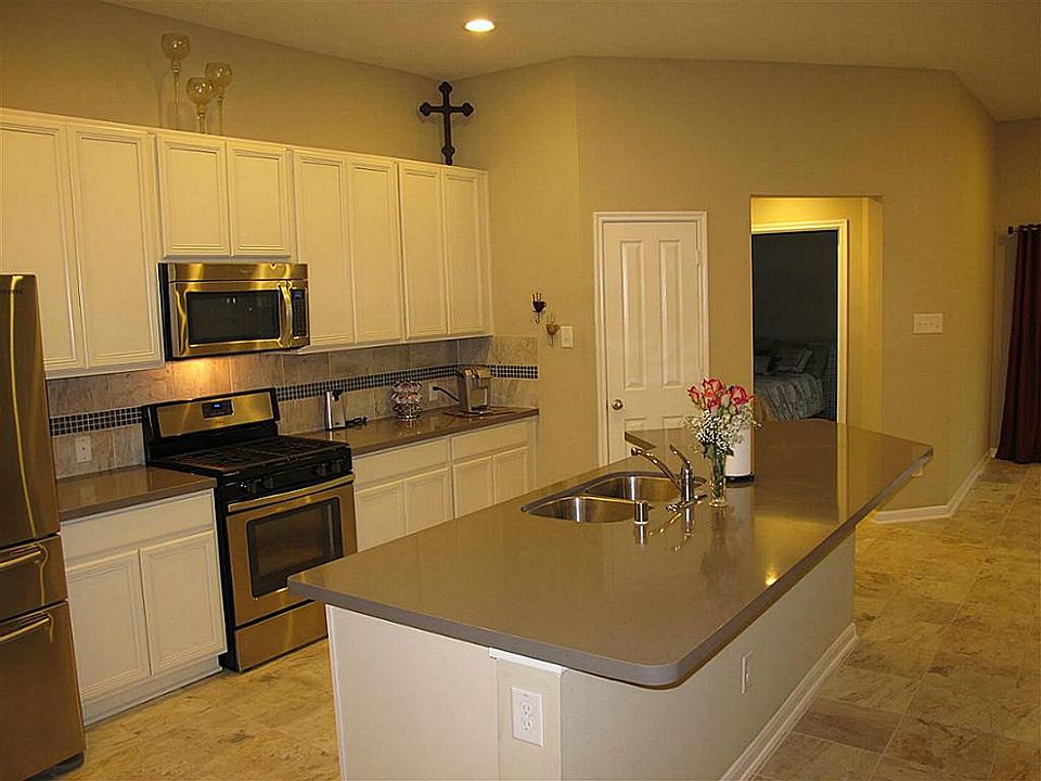 Gourmet island kitchen boasts silestone countertops, ceramic tile flooring & backsplash, 42" cabinetry, stainless steel appliances, recessed lighting, & large island/serving bar! Chef's delight!