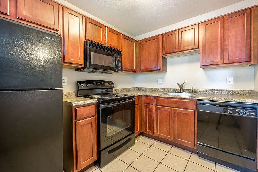 Stone Garden on Birch kitchen area with appliances, cabinets, and counters