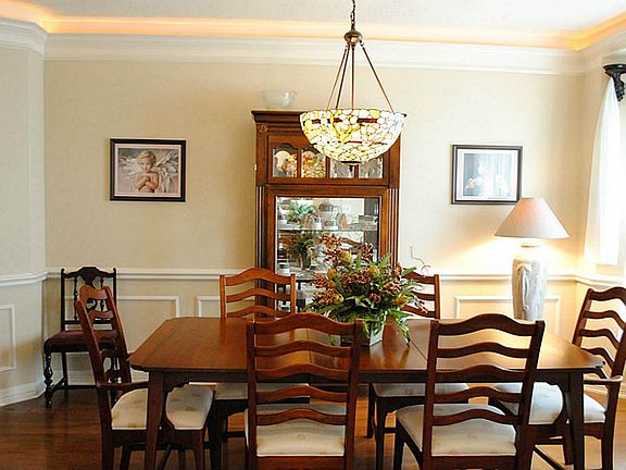 The formal dining room features hard wood floors, crown molding. and chair rails.