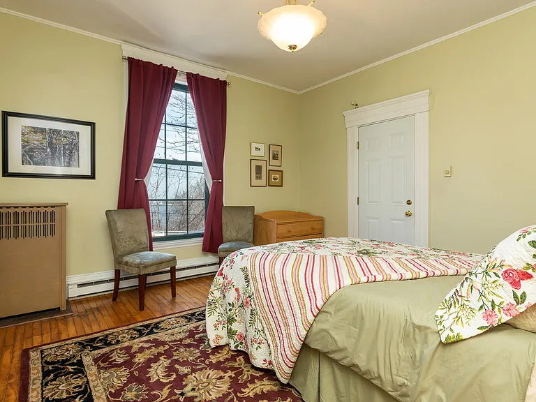 Bedroom with window toward harbor, room darkening curtains.