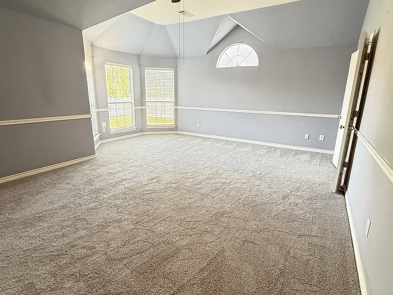 spacious master bedroom with vaulted ceilings and plush new carpet