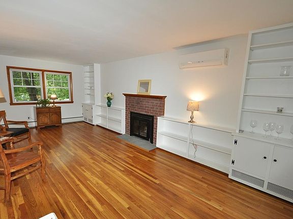 Large living room with refinished hardwood floors, fireplace and built-in bookcases.
