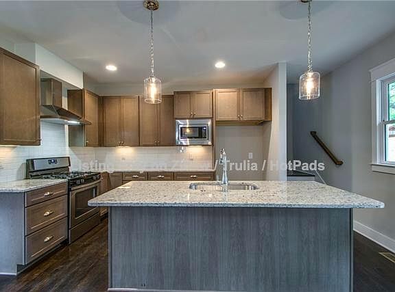 Kitchen with, breakfast bar and open floor plan to living room (behind).