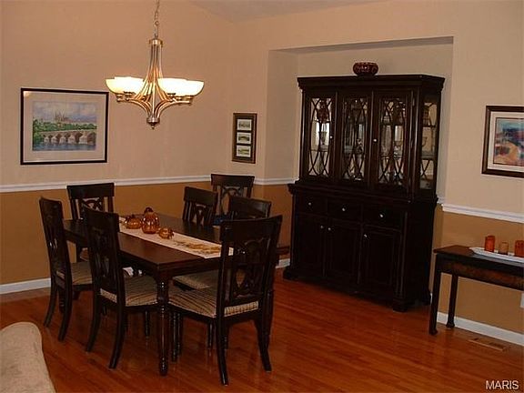 Elegant dining room with wood floors & chair rail.