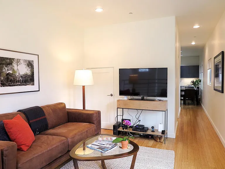 Living Room with Adjacent Hallway Leading to Guest Bathroom and Kitchen