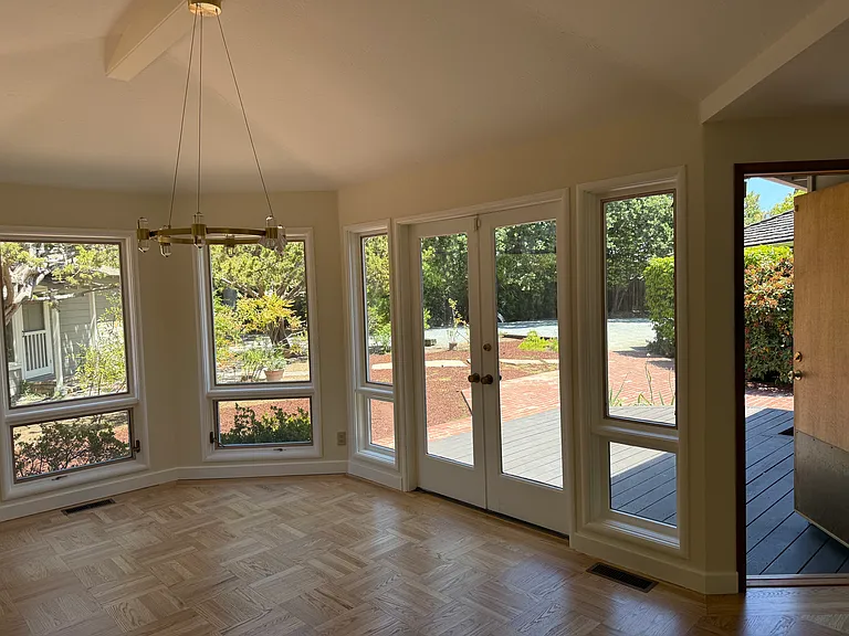 Formal dining with French door overlooking patio and backyard.