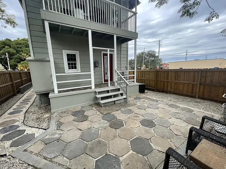 Rear view showing fenced patio. Both porches have been screened since this photo was taken.