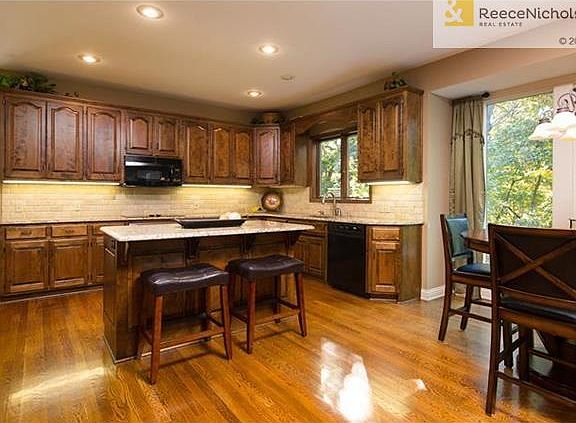 Large kitchen with island, beautiful wood floors and eating area.