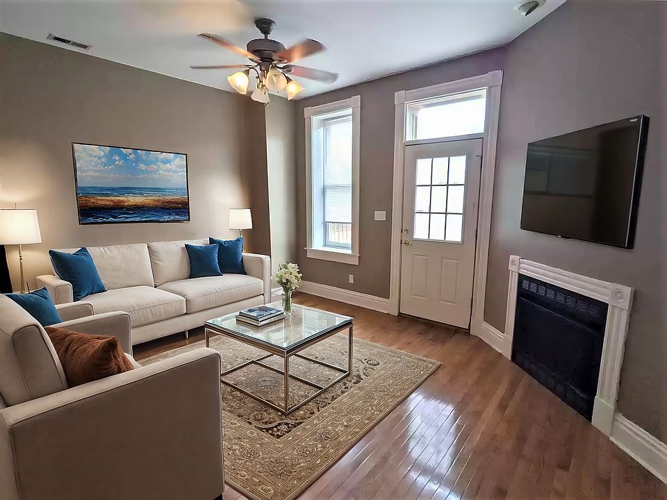 Open Lvrm space with faux fireplace and gleaming hardwood floors (virtual staged)