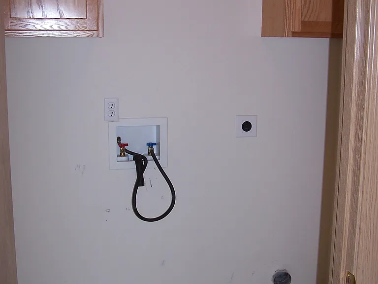Laundry room with washer dryer hook-ups. Bar for hanging cloths.