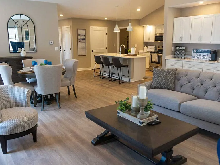 Interior of Champion Reserve Townhome Great Room showing living area, dining area, coffee bar, and kitchen area with breakfast bar.