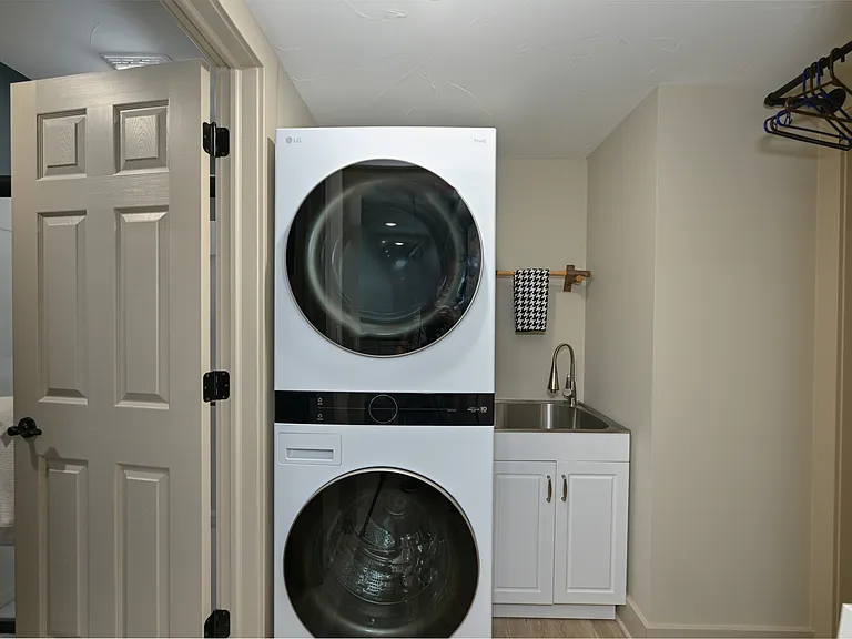 Utility Room includes convenient washer/dryer, utility sink, folding shelf and clothes hanging bar.