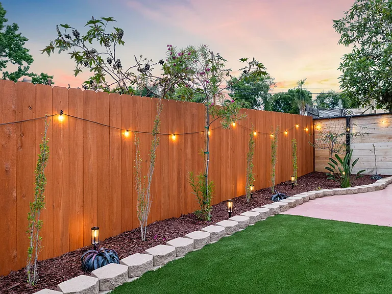 The illuminated landscaping provides a stunning, vibrant backdrop for your evening outdoors.