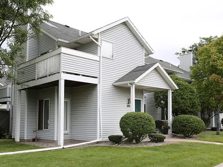 View of exterior showing wooden balcony and private, covered front entrance
