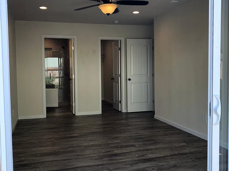 Master Bedroom with large walk-in closet and en suite bathroom. Screened sliding glass door leads to backyard.