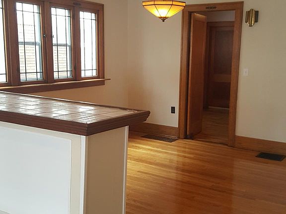 Entertainment bar with lighted shelving separates living roo