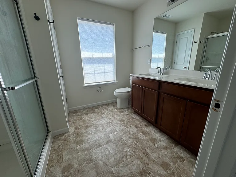 En-suite bathroom with shower and double vanity sinks