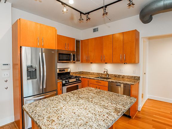 Spacious kitchen with island, granite and stainless steel appliances.
