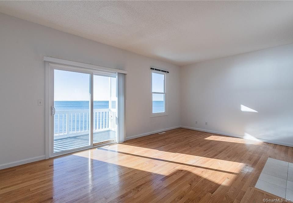 Large living room with hardwood floors, FPL and slider to deck