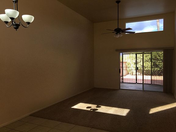 View from the dining room to living room and enclosed Arizona room in afternoon light.
