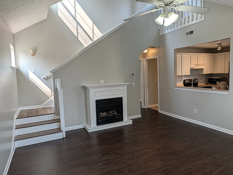 Spacious living room featuring brand-new luxury vinyl plank flooring, vaulted ceilings, and a fireplace.