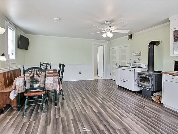 As you enter, you will find great flooring, large open kitchen and dining with wood stove and classic range/oven. >