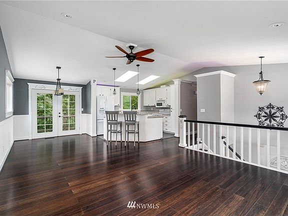 In the furnished option, there is a large sectional couch, TV, area rugs, and a couple pieces of wall art in this living room space