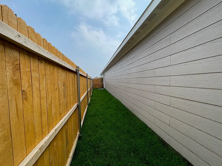 Side yard looking to the front toward side entry door