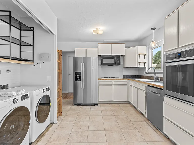 With plenty of room to move around, the kitchen offers generous cabinetry, newer stainless steel appliances, and convenient in-unit laundry.