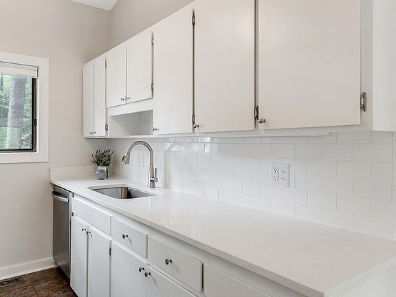 Bright kitchen with quartz countertops & tile backsplash